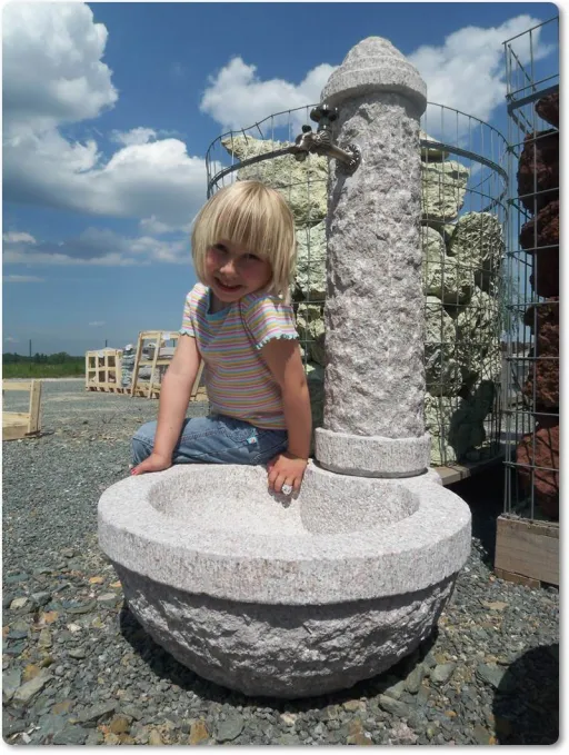 Granitbrunnen rustikal und rund aus grauem Granit