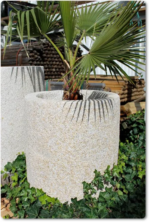 Runder Kübel aus gelbem Naturstein für den Garten