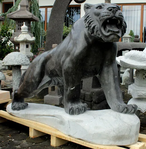 Schwarzer Tiger aus Kalkstein auf Steinsockel für die Gartengestaltung