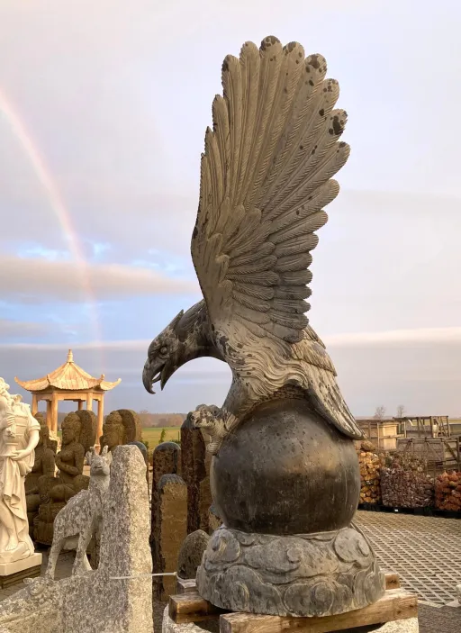 Imposanter Adler mit ausgebreiteten Flügeln auf Kugel