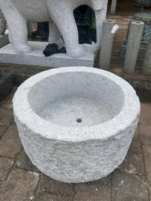 Runder Steintrog für den Garten mit Bohrung im Boden