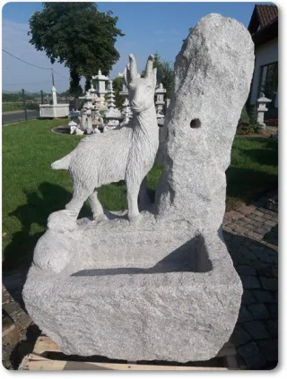 Rustikaler Gartenbrunnen mit Ziege